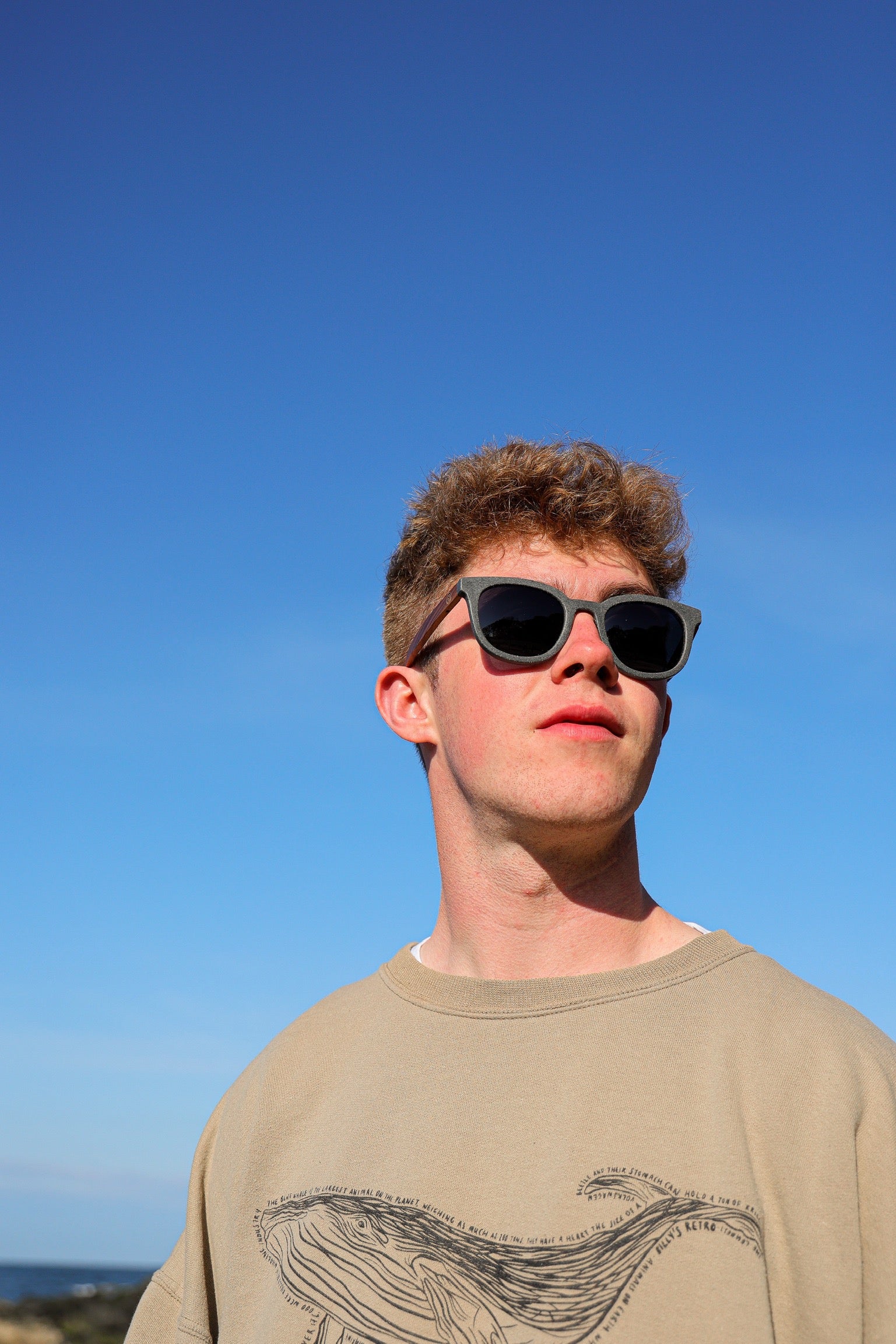 Made with sustainable speckled charcoal wheat straw or coffee residue frame and walnut wood temples, these stylish shades are lightweight, comfortable and eco-friendly with their plastic alternative materials. Fitted with UV400 polarised lenses in a smoke black colour and subtle logo is engraved on the temples. Sunglasses come with a padded pouch and microfibre cleaning cloth. 