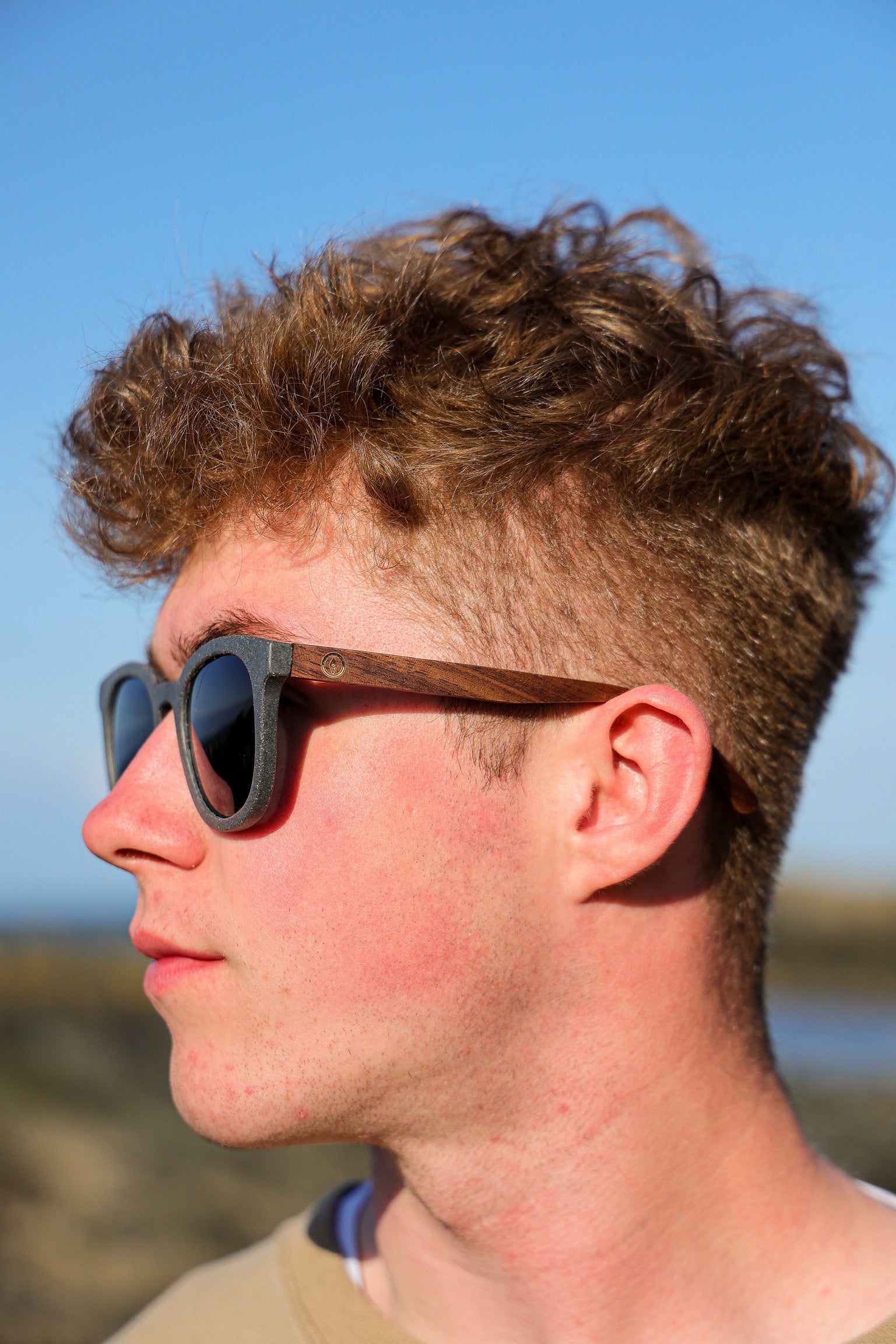 Made with sustainable speckled charcoal wheat straw or coffee residue frame and walnut wood temples, these stylish shades are lightweight, comfortable and eco-friendly with their plastic alternative materials. Fitted with UV400 polarised lenses in a smoke black colour and subtle logo is engraved on the temples. Sunglasses come with a padded pouch and microfibre cleaning cloth. 